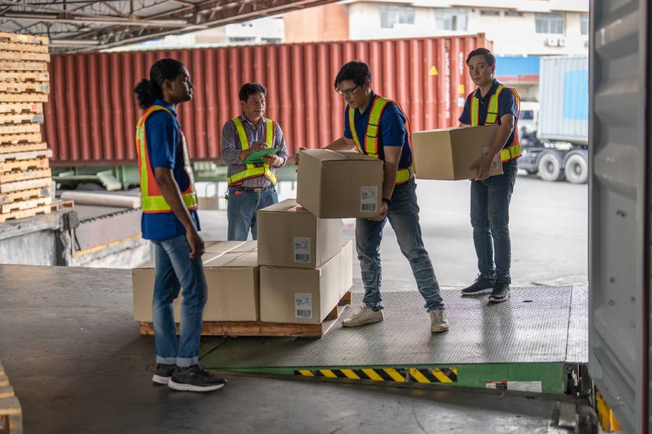 Trabajadores suben cajas de cartón al transporte 