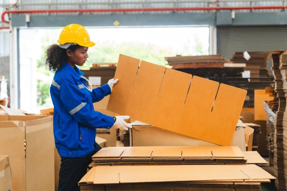 Mujer en línea de producción de cajas de cartón