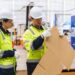 trabajadores aplican pruebas de calidad sobre una caja de cartón